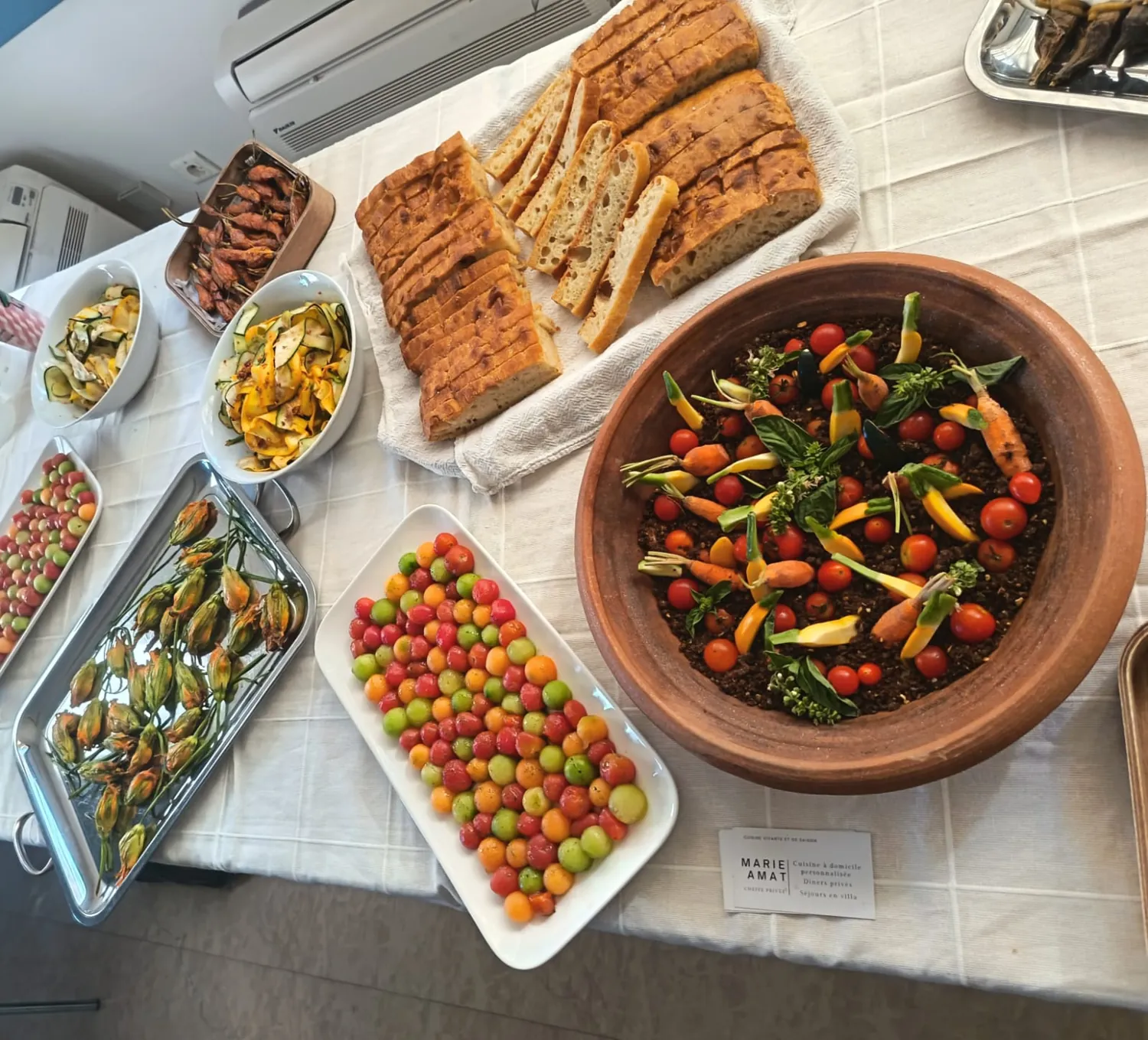 Buffet : un bol en terre cuite de tomates et de petites carottes, tomates multicolores